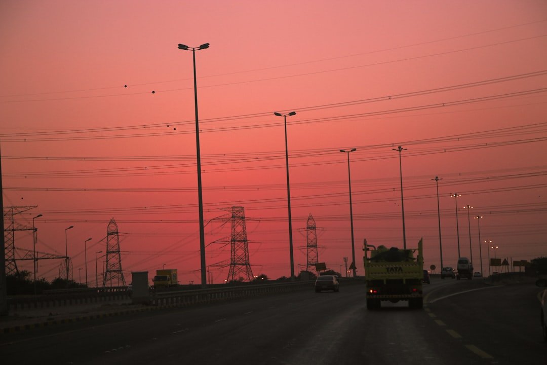 Car on the highway silhouetted against a sunset sky
