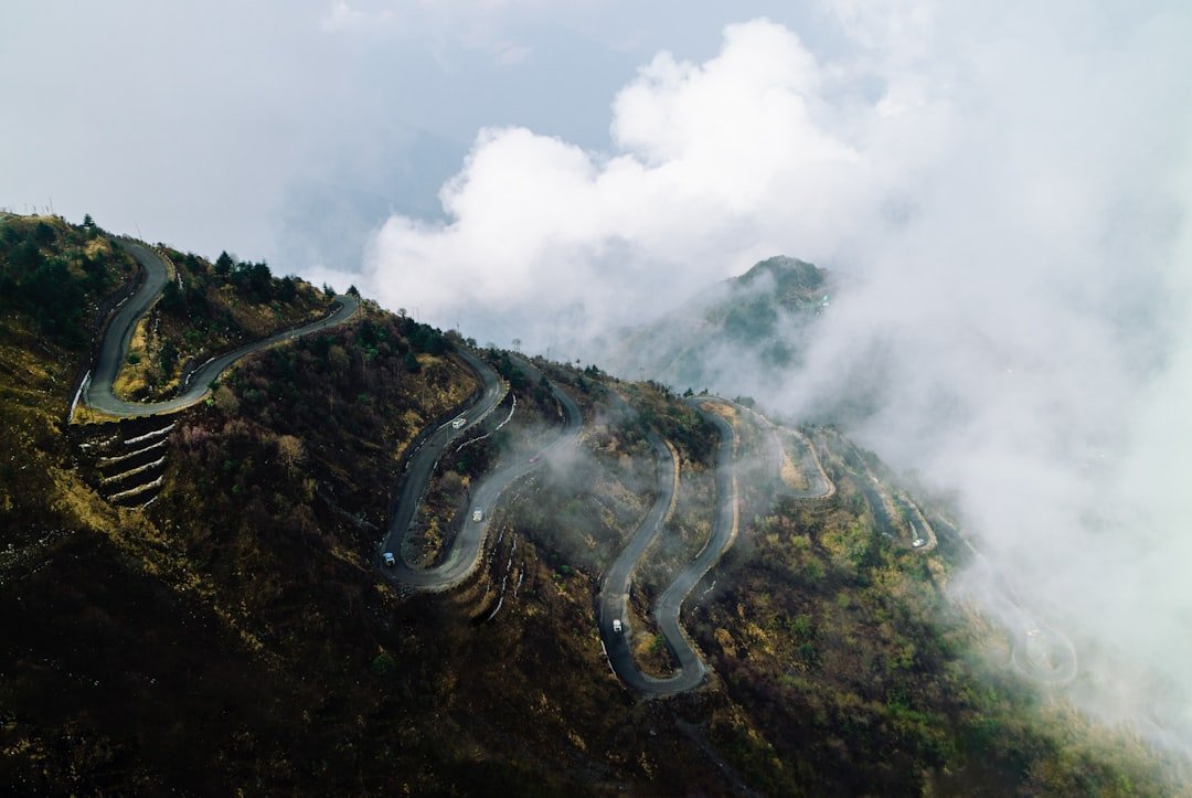 Curving hill road with clouds rolling over the hills